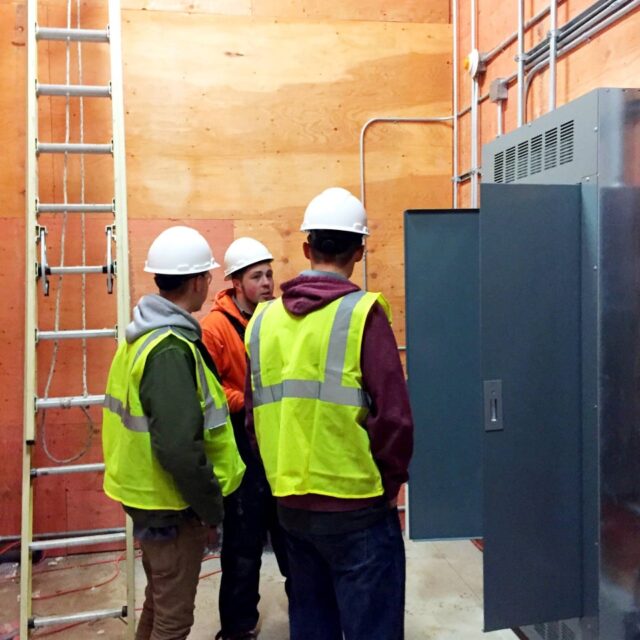3 people at an electrical breaker box