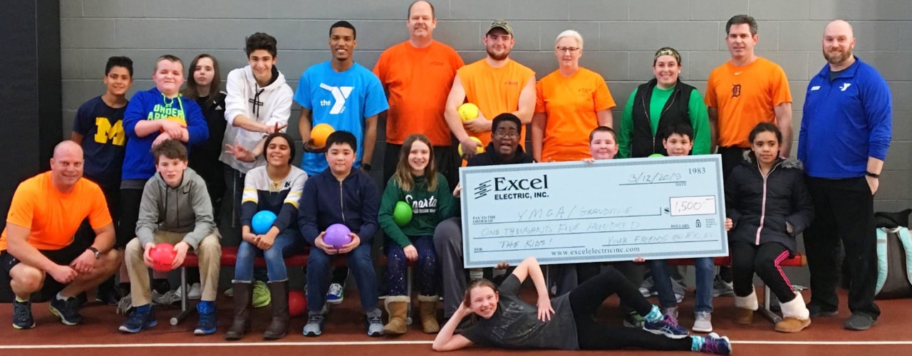 Excel employees donating a big check to the ymca
